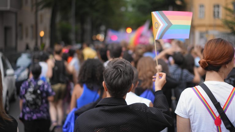 Lesbian woman enjoy lgbt pride month. Girl waving rainbow flag. Gay community.